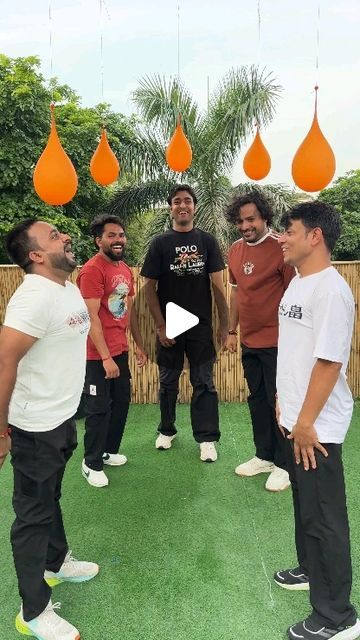 a group of men standing next to each other on top of a lush green field