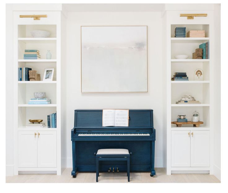 a blue piano sitting in front of a white bookcase with books on top of it