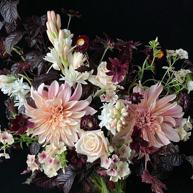 a vase filled with lots of pink and white flowers