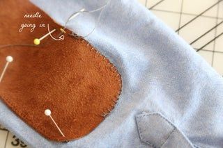 a piece of fabric is being sewn on with sewing needles and thread in it