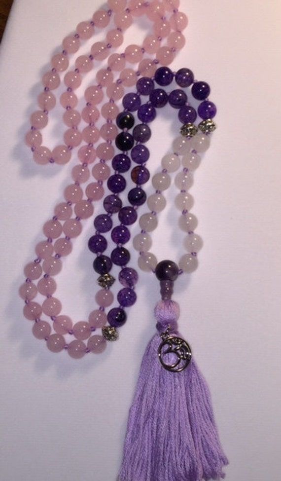 "Zen 108 Bead Mala. Silver spacer beads marked at 7-14-66. Silver marker beads with Amethyst guru bead, tassel and Om charm. Mala or Buddhist prayer beads, are a traditional tool used to count the number of times a mantra or the name or names of a deity is recited while meditating. The mala is used so that one can focus on the meaning or sound of the mantra rather than counting its repetitions. They are similar to other forms of prayer beads used in various world religions.  They are usually mad Spiritual Purple Spacer Beads, Hand-strung Purple Bohemian Beads, Bohemian Hand-strung Purple Beads, Purple Hand-strung Bohemian Beads, Purple Bohemian Hand-strung Beads, Spiritual Purple Beaded Bracelets For Meditation, Purple Round Beads Bracelet For Meditation, Purple Round Beaded Bracelets For Meditation, Purple Beaded Bracelets For Meditation