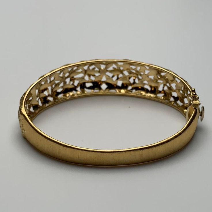 This is part of Chairish’s Fine Jewelry assortment.  This bangle is hand-crafted out of 18 karat yellow gold. It features delicate, florentine engravings of leaves and small flowers. The clasp contains one safety clasp.   Weight: 17.75g Size: 6.5" Gold Engraved Diamond Bracelet For Wedding, Exquisite Yellow Gold Bangle For Anniversary, Gold Engraved Bangle Fine Jewelry, Classic Gold Bangle For Evening, Elegant Engraved Gold Bangle Bracelet, Engraved Diamond Bangle Bracelet For Wedding, Formal Hinged Yellow Gold Bracelet, Fine Jewelry Gold Bracelet With Intricate Design, Elegant 22k Gold Round Bracelet