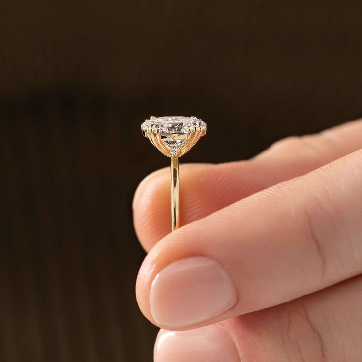 a person holding a diamond ring in their hand