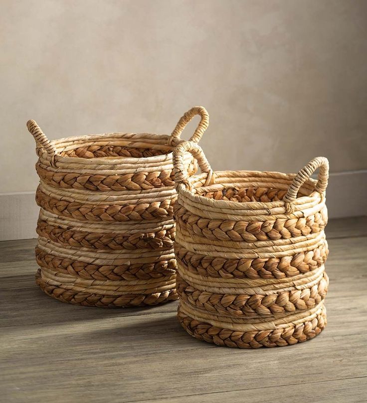 three woven baskets sitting on top of a wooden floor