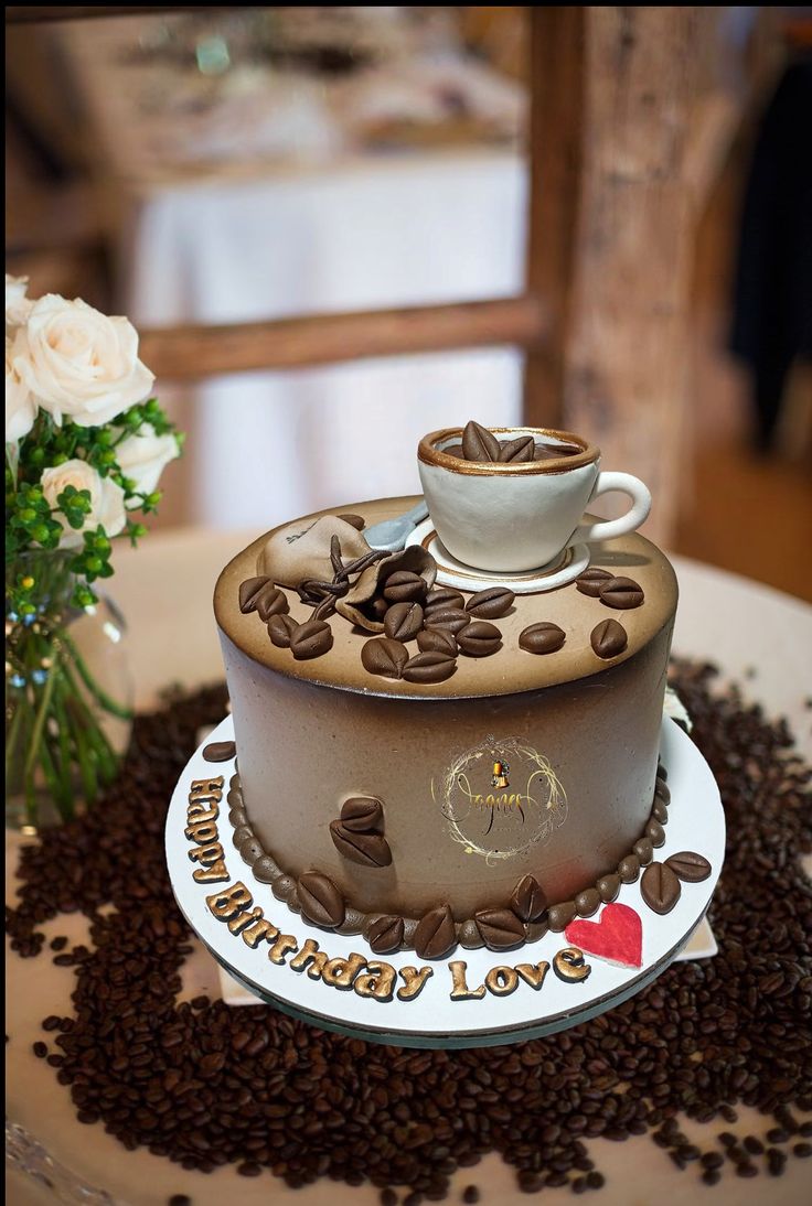 a birthday cake with coffee beans on top and a cup of coffee in the middle