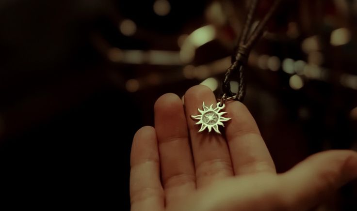 a person holding a small star shaped object in their hand with the light shining on it