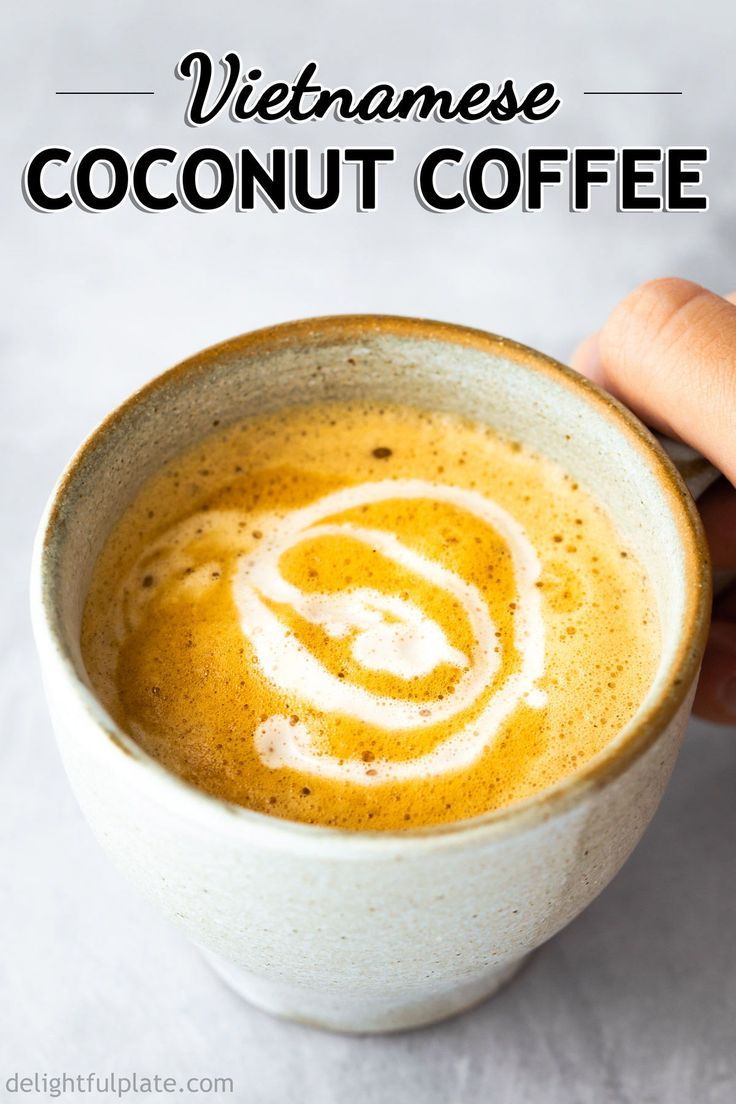 a hand holding a cup of coffee with the words vietnamese coconut coffee on top and bottom