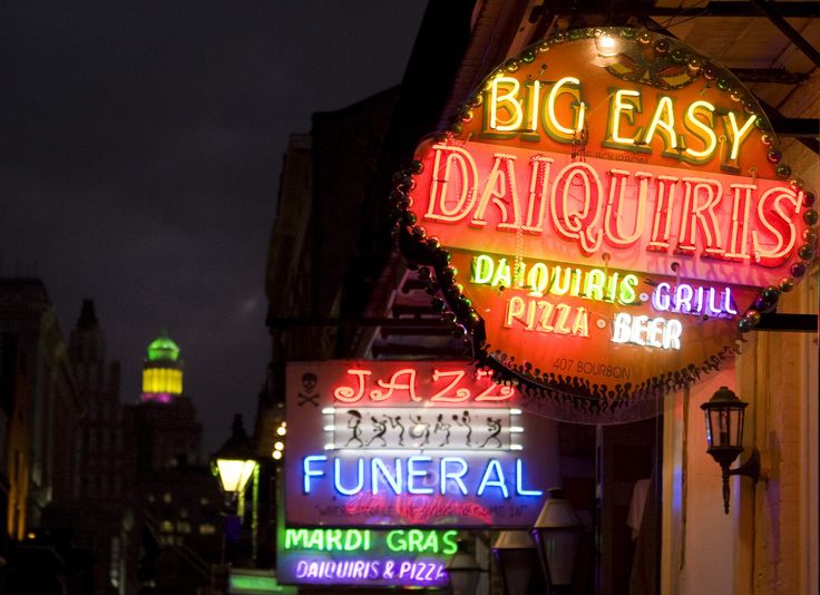 neon signs are lit up on the side of buildings