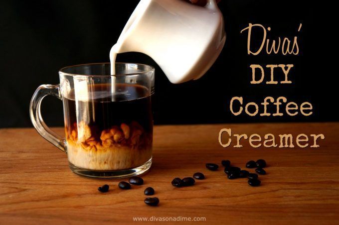 coffee being poured into a glass mug filled with creamer and black beans on a wooden table