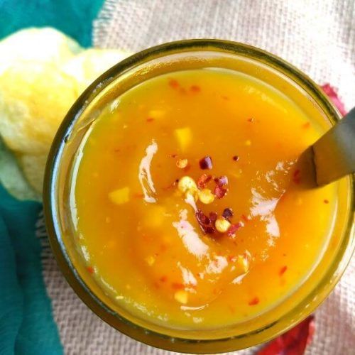 a close up of a glass with food in it and a spoon on the side