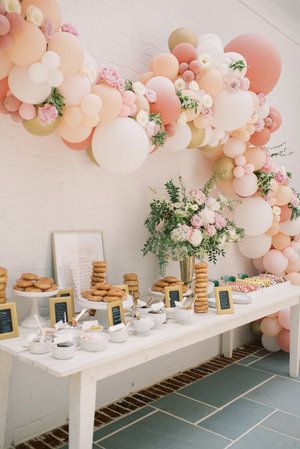 a table with desserts and balloons on it