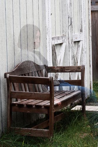 a wooden bench sitting next to a white building