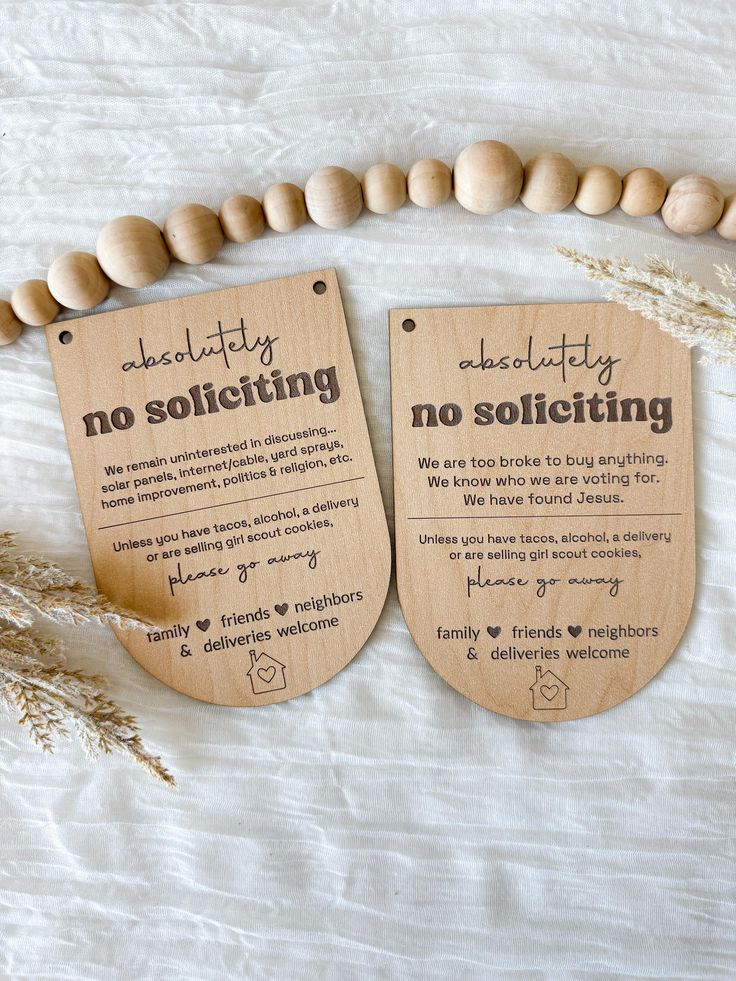 two wooden tags that say no solicizing and no solicizing