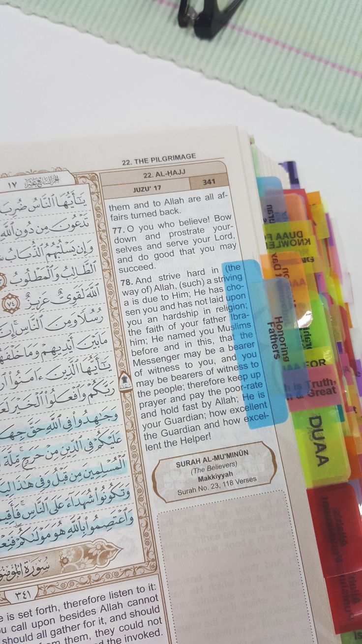 an open book with arabic writing on it and some pens in front of the page