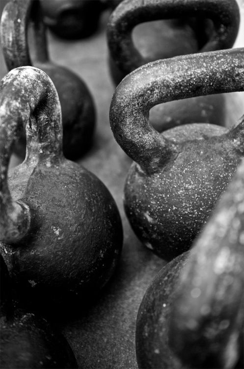 black and white photograph of kettles with chains