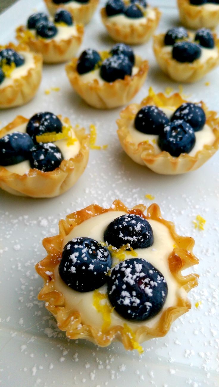 blueberry and lemon tarts on a white tray