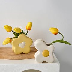 some yellow flowers are sitting in a vase on a white shelf with a wooden board