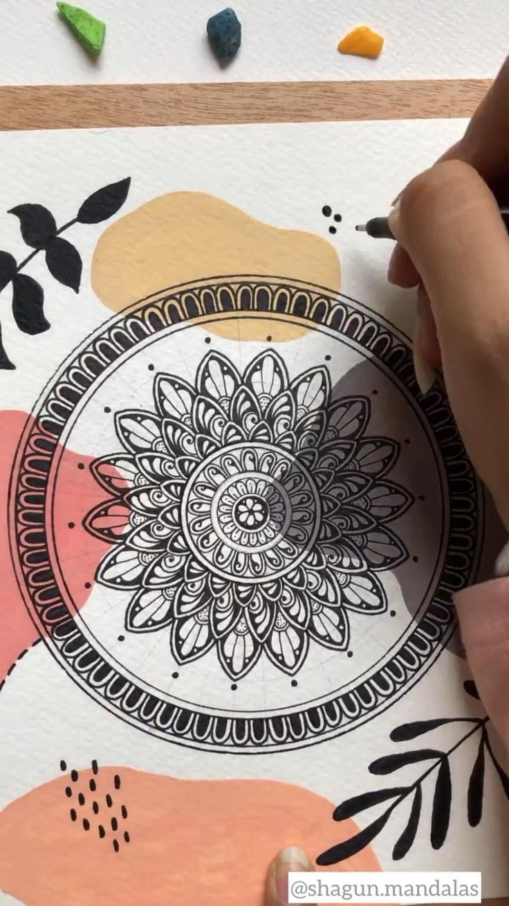 someone is using colored crayons to draw a flower design on paper with markers