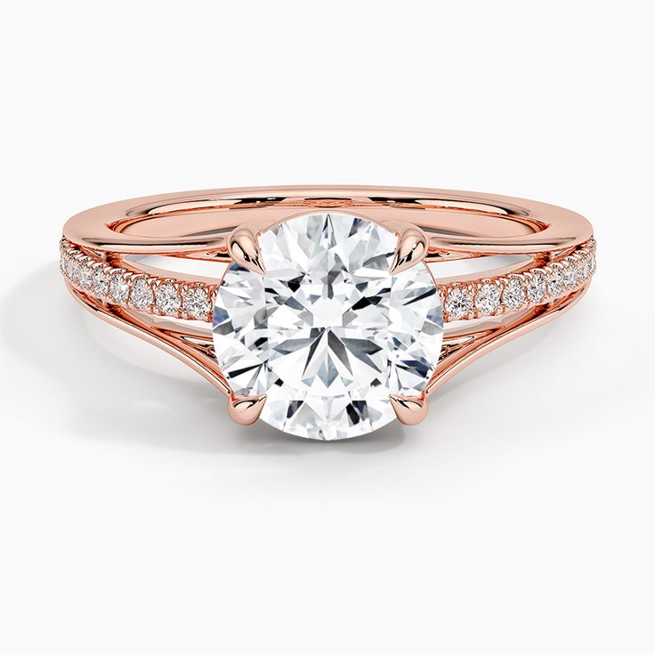 a rose gold engagement ring with a round cut diamond in the center and pave set shoulders