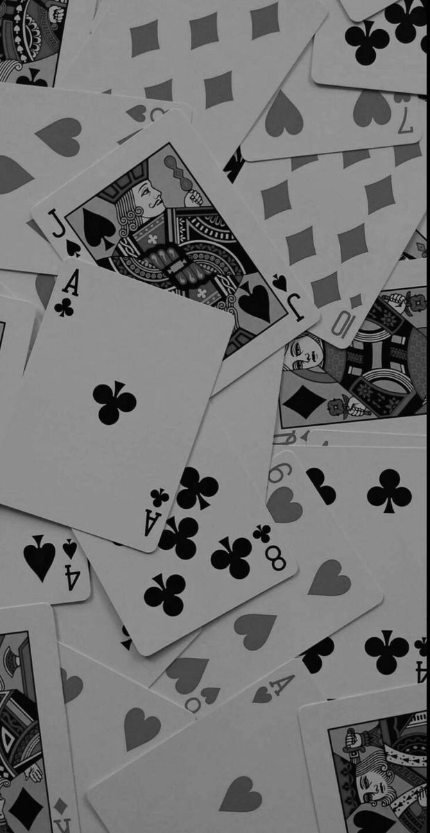 many playing cards are scattered on top of each other in black and white, including one with fours