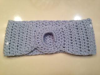 a crocheted headband with a button on it