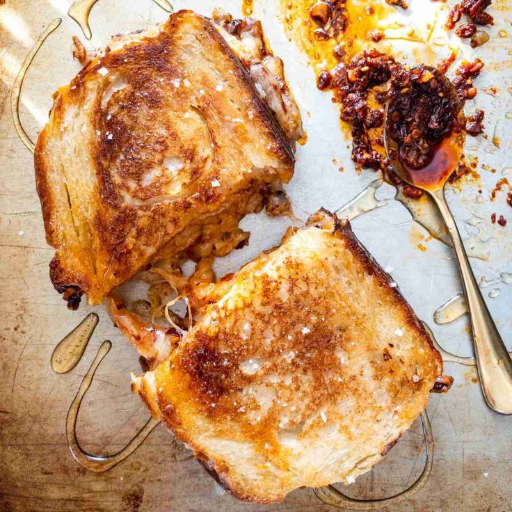 two pieces of grilled cheese sitting on top of a table next to a fork