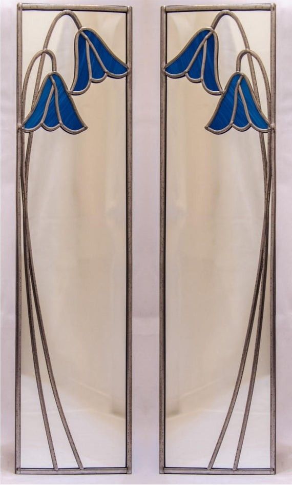 two stained glass doors with blue flowers on the front and back panels, one is open