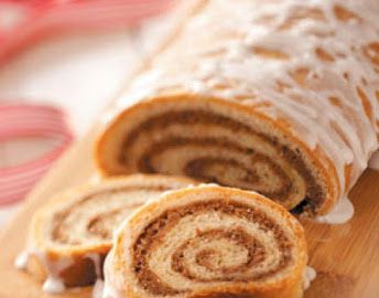 a cinnamon roll cut in half on a cutting board