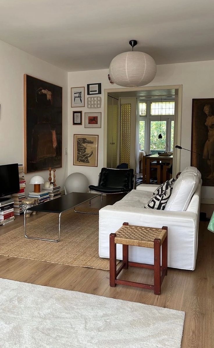 a living room filled with furniture and pictures on the wall