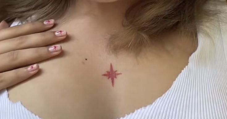 a woman with pink and white nail polish holding her chest