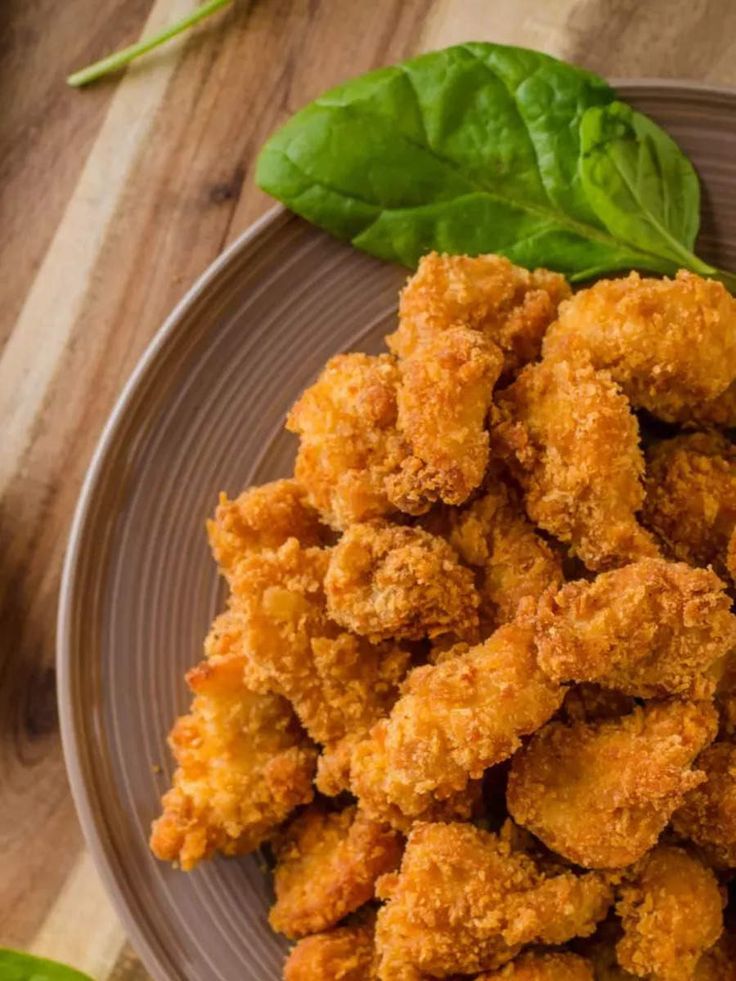 some fried food is on a plate with spinach leaves