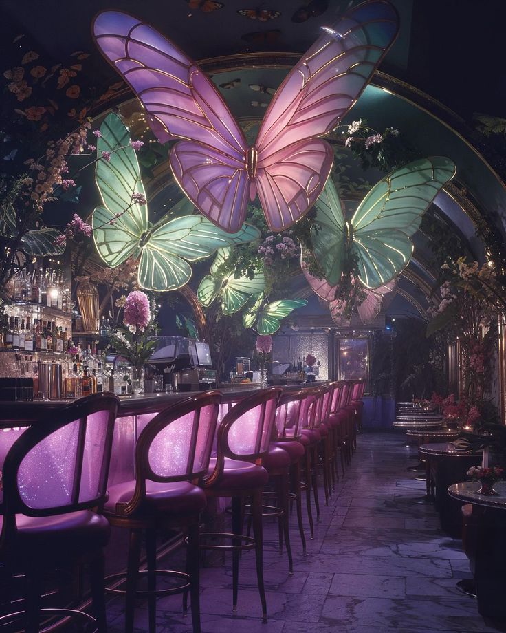 a bar with pink chairs and large butterflies hanging from the ceiling