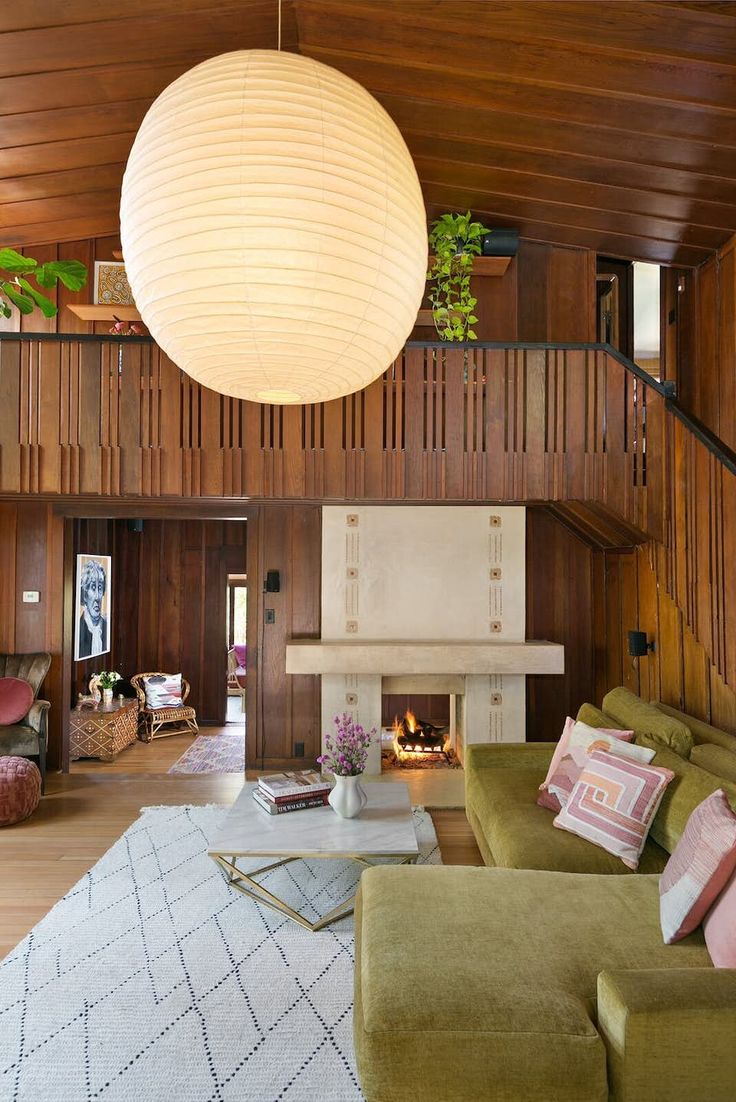 a living room filled with lots of furniture and a large light hanging over the fireplace