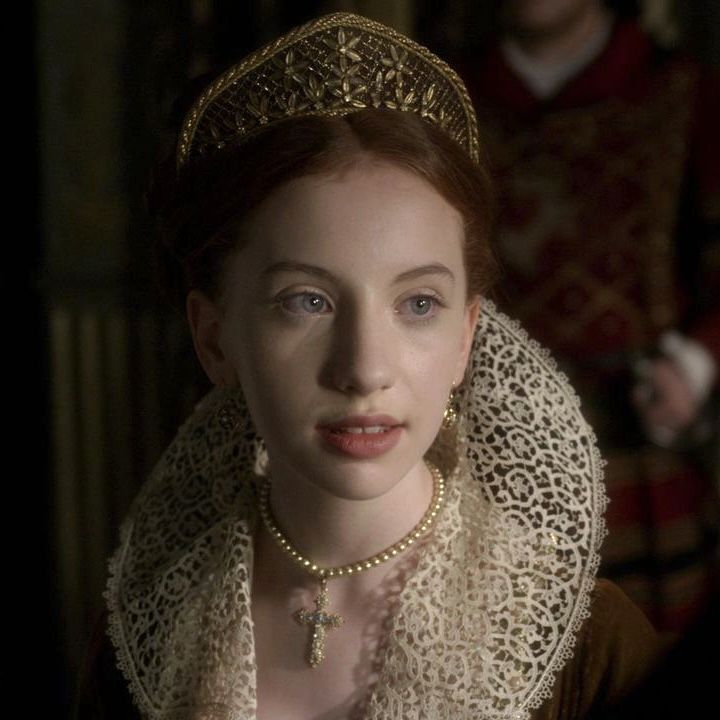 a woman wearing a tiara and pearls on her head in a scene from the tudors