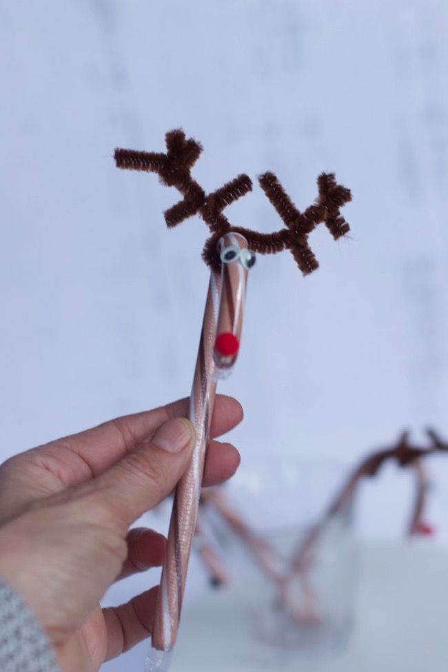 a person holding a toothbrush with reindeer antlers on it