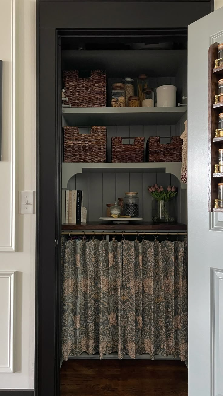 an open pantry door with baskets and other items on the shelves