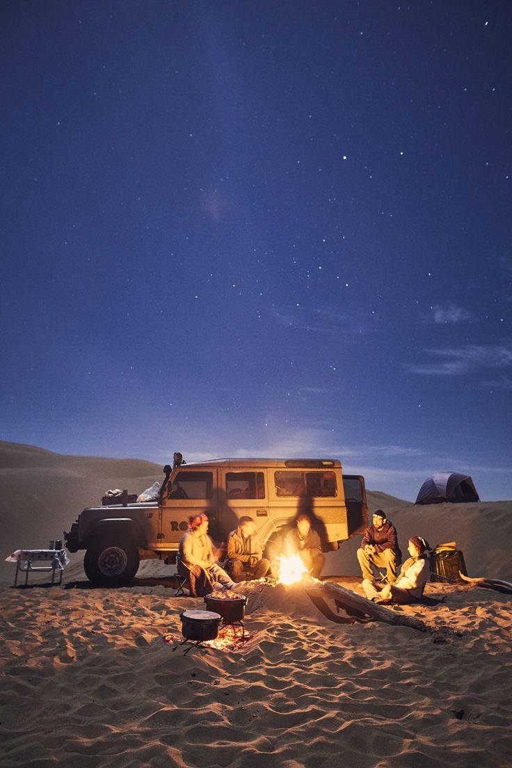 people sitting around a campfire in the desert