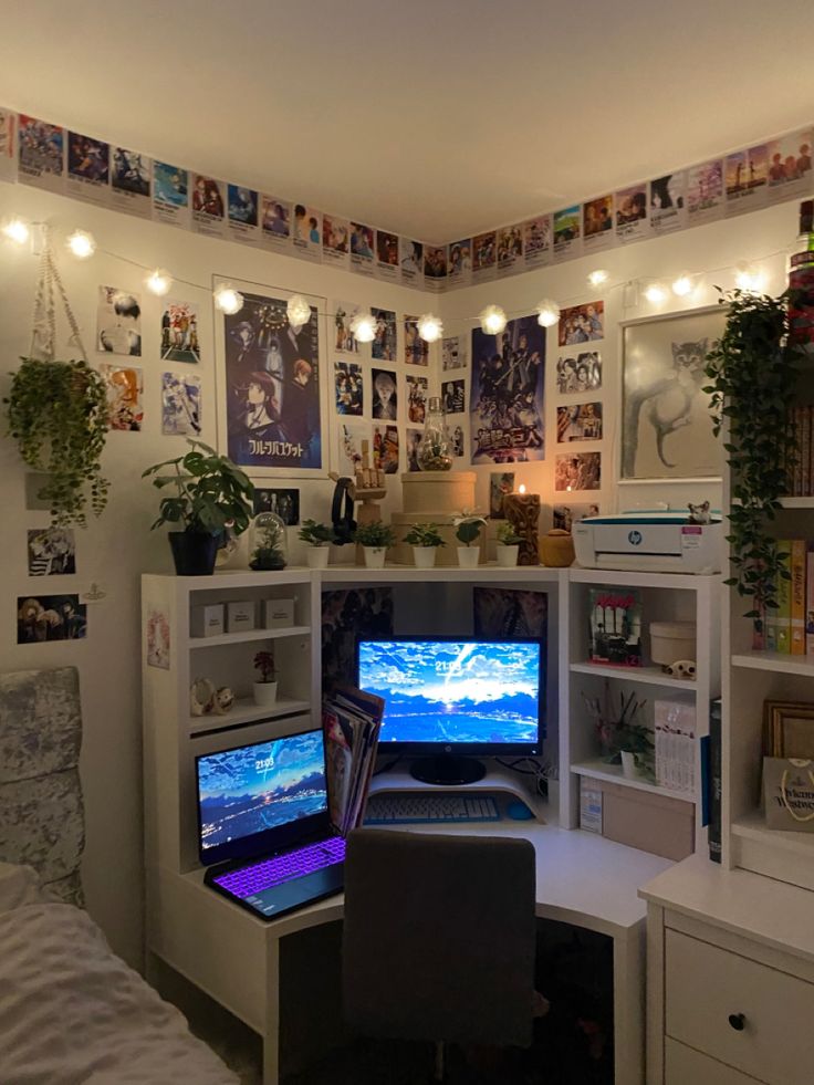 a computer desk with two monitors on it in front of a wall full of pictures