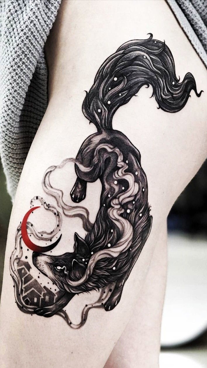 a woman's thigh with a black and white tattoo design on the side of her leg