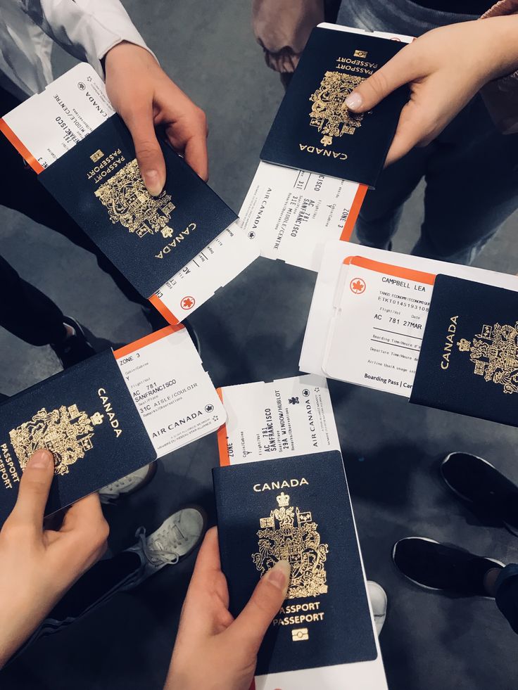 four people holding up their canadian passport cards