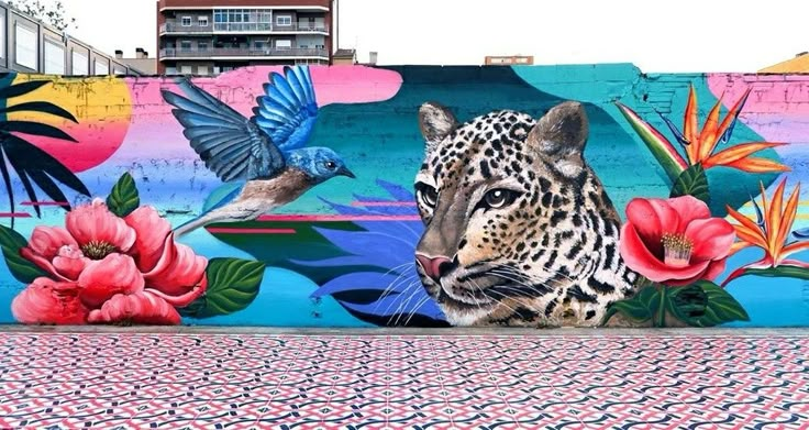 a leopard painted on the side of a building with flowers and birds flying around it