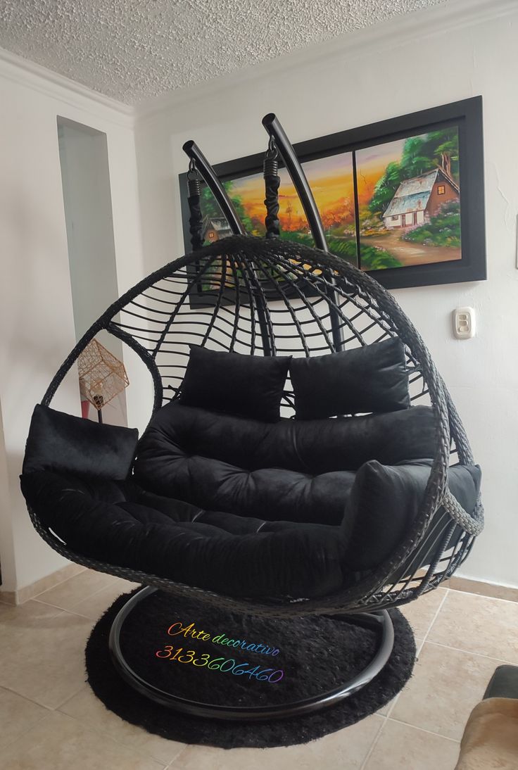 a black hanging chair in the corner of a room