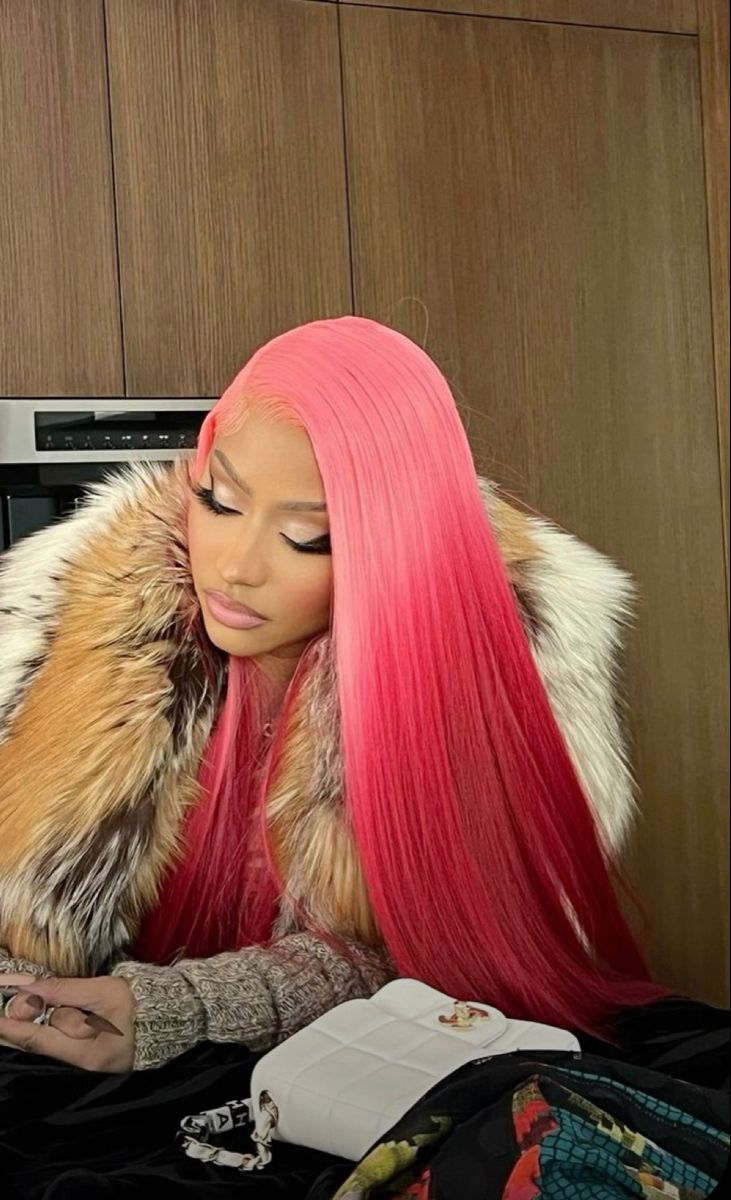 a woman with long pink hair sitting in front of a microwave