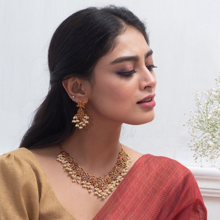 About the Jewelry Stand out from the crowd with this elegant antique necklace set. This floral intricate antique necklace is a dreamy affair for every woman. Made with high-quality Kempu stone, this Gutta Pusalu inspired necklace set is great for the woman who loves the fusion of Indian cultural heritage and fashion trends. Styling Tip Match it with a beautiful traditional golden embellished silk saree on your special day. Details & Specifications: Materials used: Kempu Stone with Antique Platin Radha Raman, Indian Necklace Set, Antique Necklace Set, Jhumka Designs, Stone Necklace Set, Necklace Set Indian, Gold Jewelry Simple Necklace, Heritage Jewellery, Celebrity Jewelry