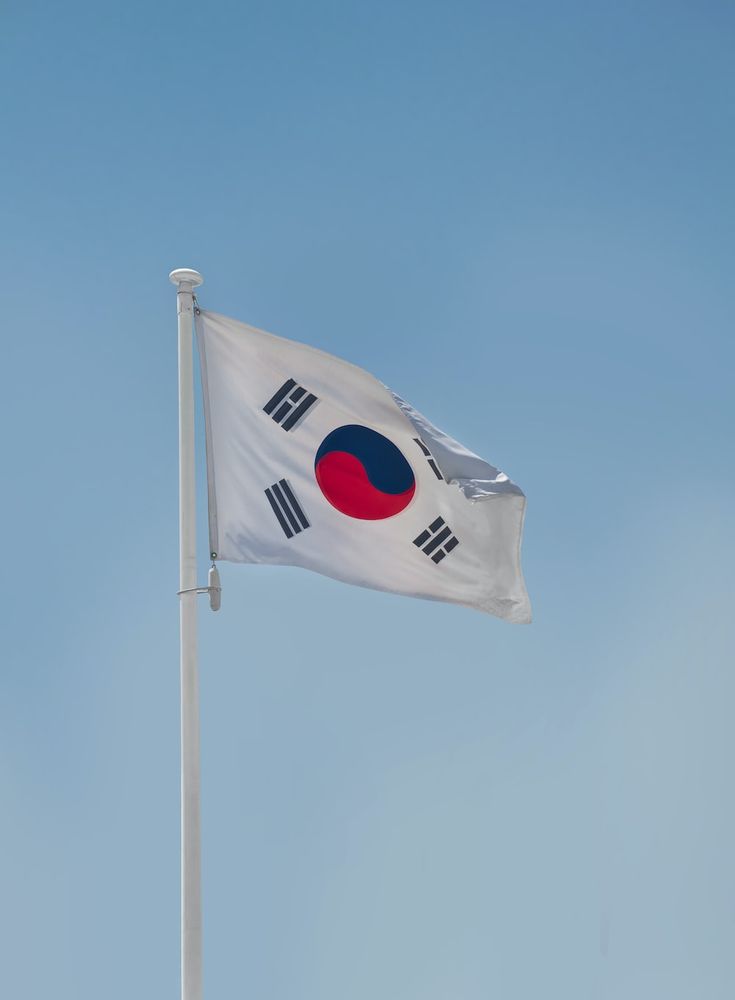 the korean flag is flying high in the blue sky with no clouds on it's side