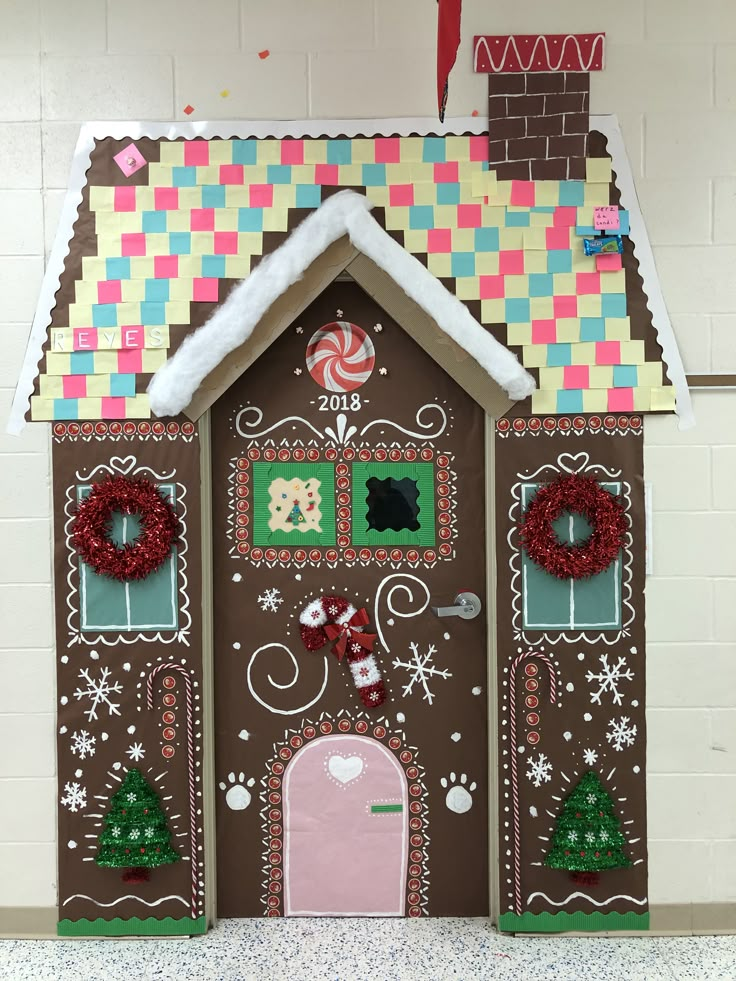 a gingerbread house decorated for christmas with candy and wreaths on the front door