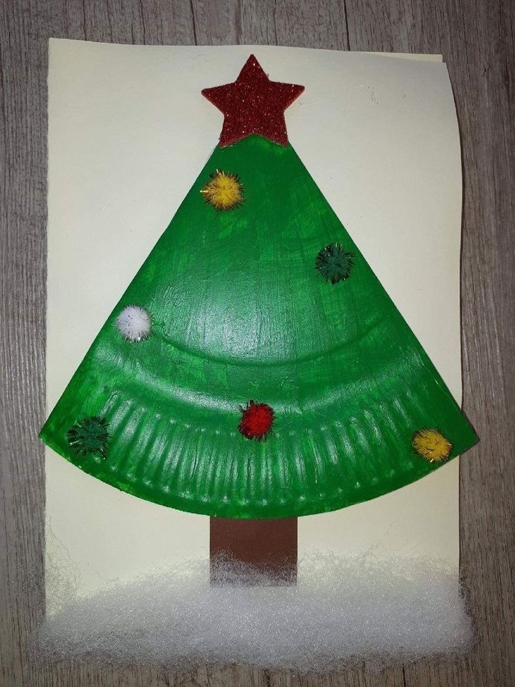 a paper plate christmas tree on top of a piece of white paper with red and green decorations