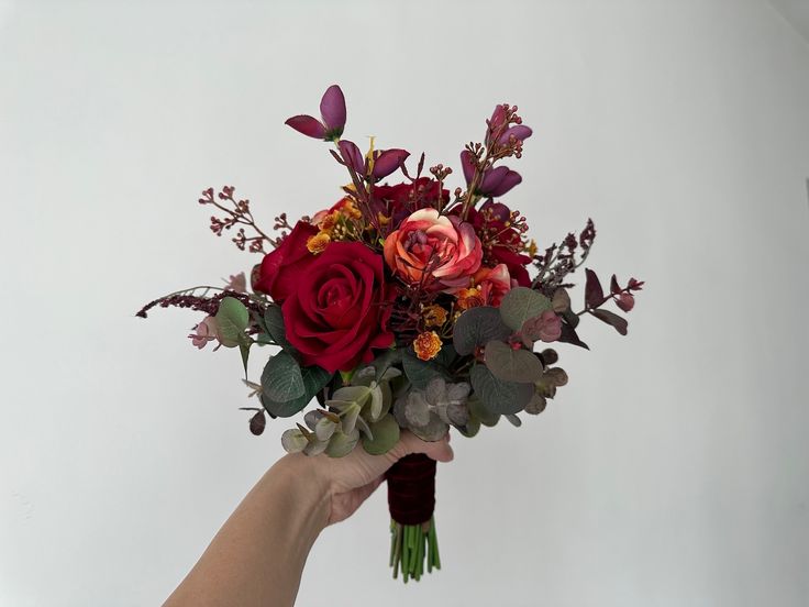 a person holding a bouquet of flowers in their hand