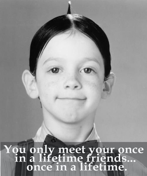 a young boy wearing a bow tie and looking at the camera with a smile on his face