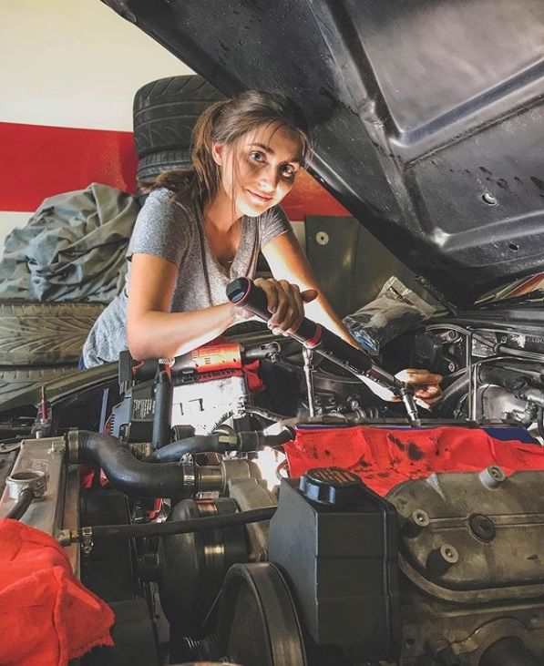 a woman working on an engine in a car